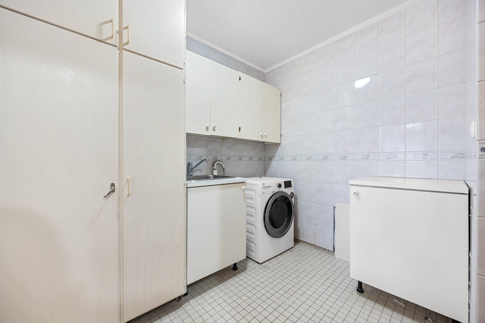 Separat vaskerom med opplegg for vaskemaskin, skyllekum og rikelig med skapplass. Galleribilde