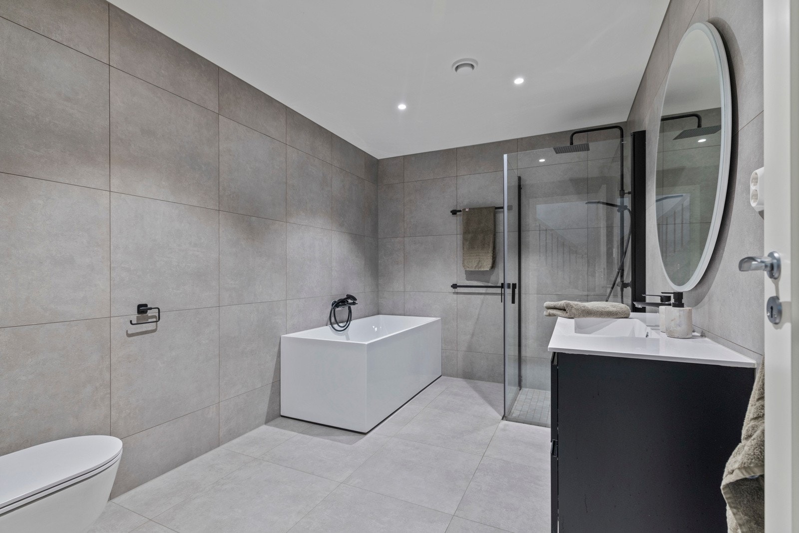 Romslig og pent flislagt bad fra byggeår med elektriske varmekabler i gulv. Galleribilde