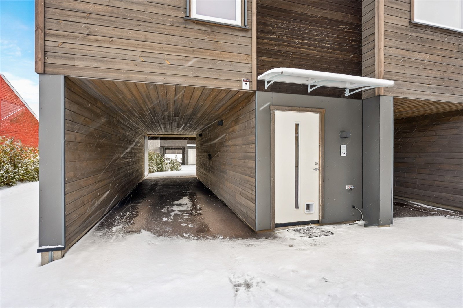 Parkering for to biler under tak med kraftig el-bil lader. Sportsbod ved uteplass. Galleribilde