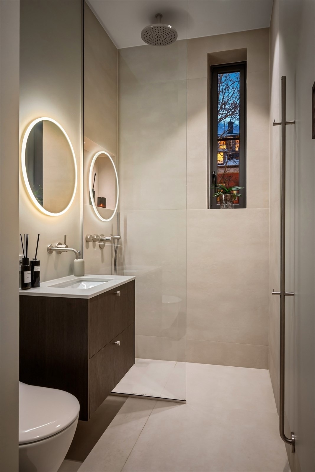 Badet er utstyrt med servant og vegghengt toalett fra Villeroy og Boch, innebygget armatur fra Dornbracht og håndkletørker fra INR. Praktisk dusjsone med regnfallsdusj på badet som gir leiligheten to komplette bad. Galleribilde