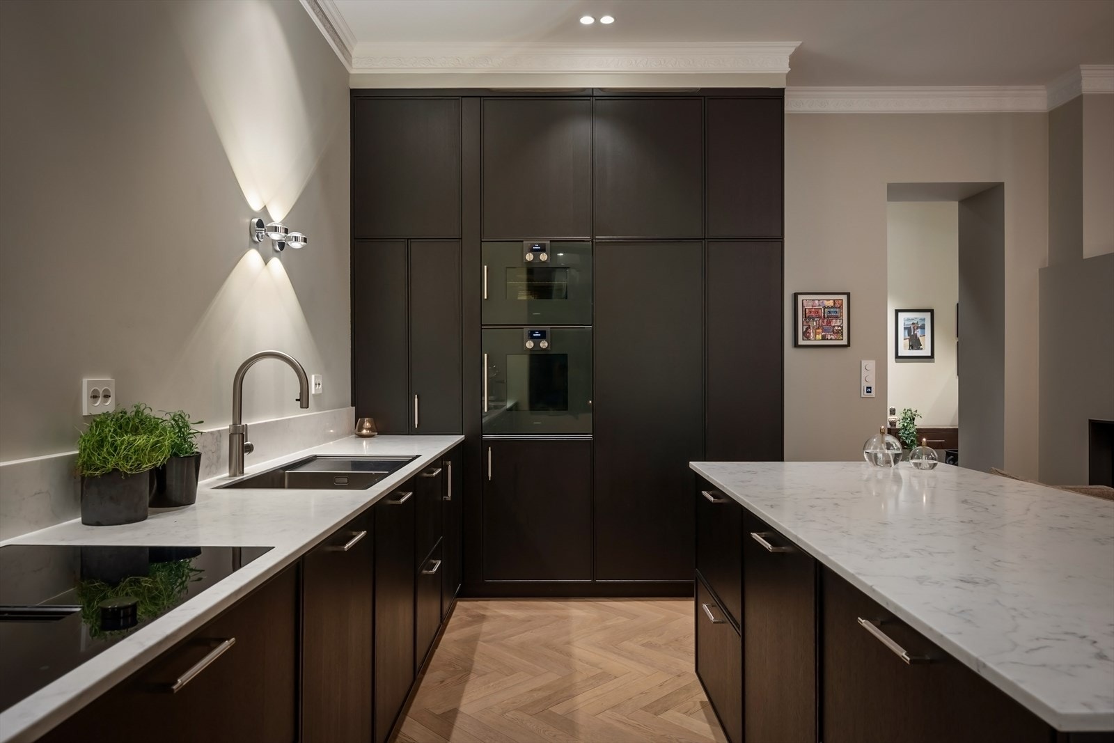 Integrert i kjøkkeninnredningen er stekeovn, kombiovn, oppvaskmaskin, kjøleskap, fryseskap og vinskap. Underlimt vaskekum og armatur fra Quooker gir enkel tilgang på kokende vann. Galleribilde