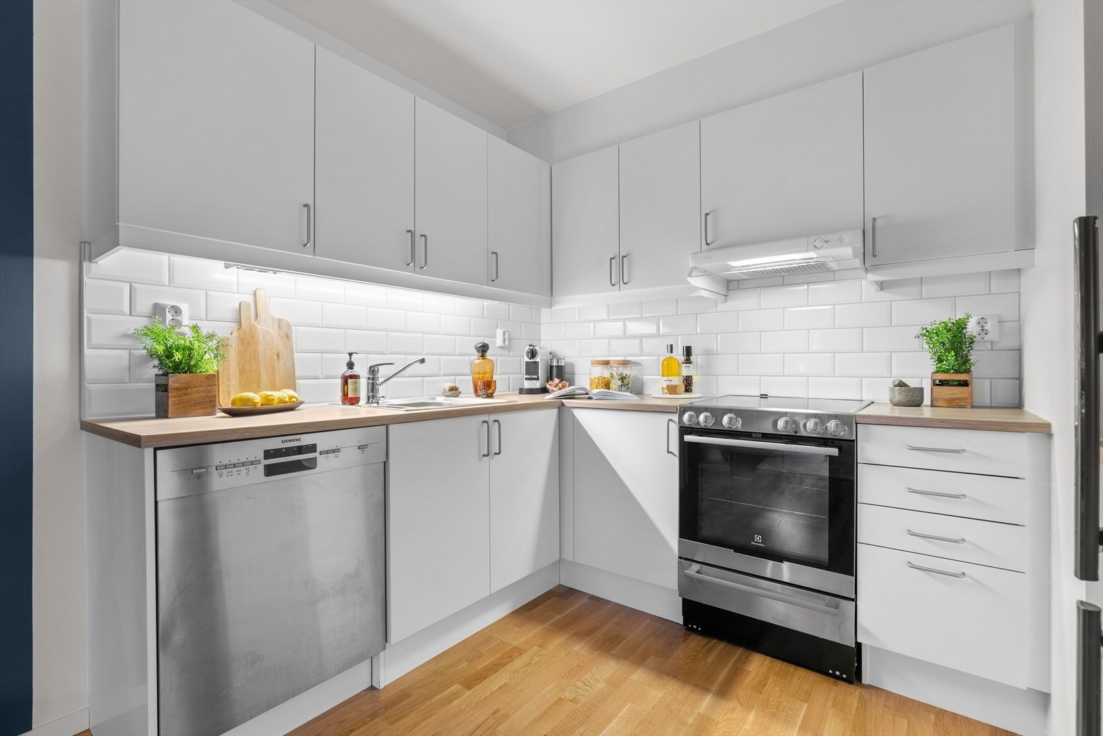 Benkeplaten er laminert og det er montert nedfelt rustfri oppvaskkum med avrenningsfelt. Veggen over benken er flislagt Galleribilde