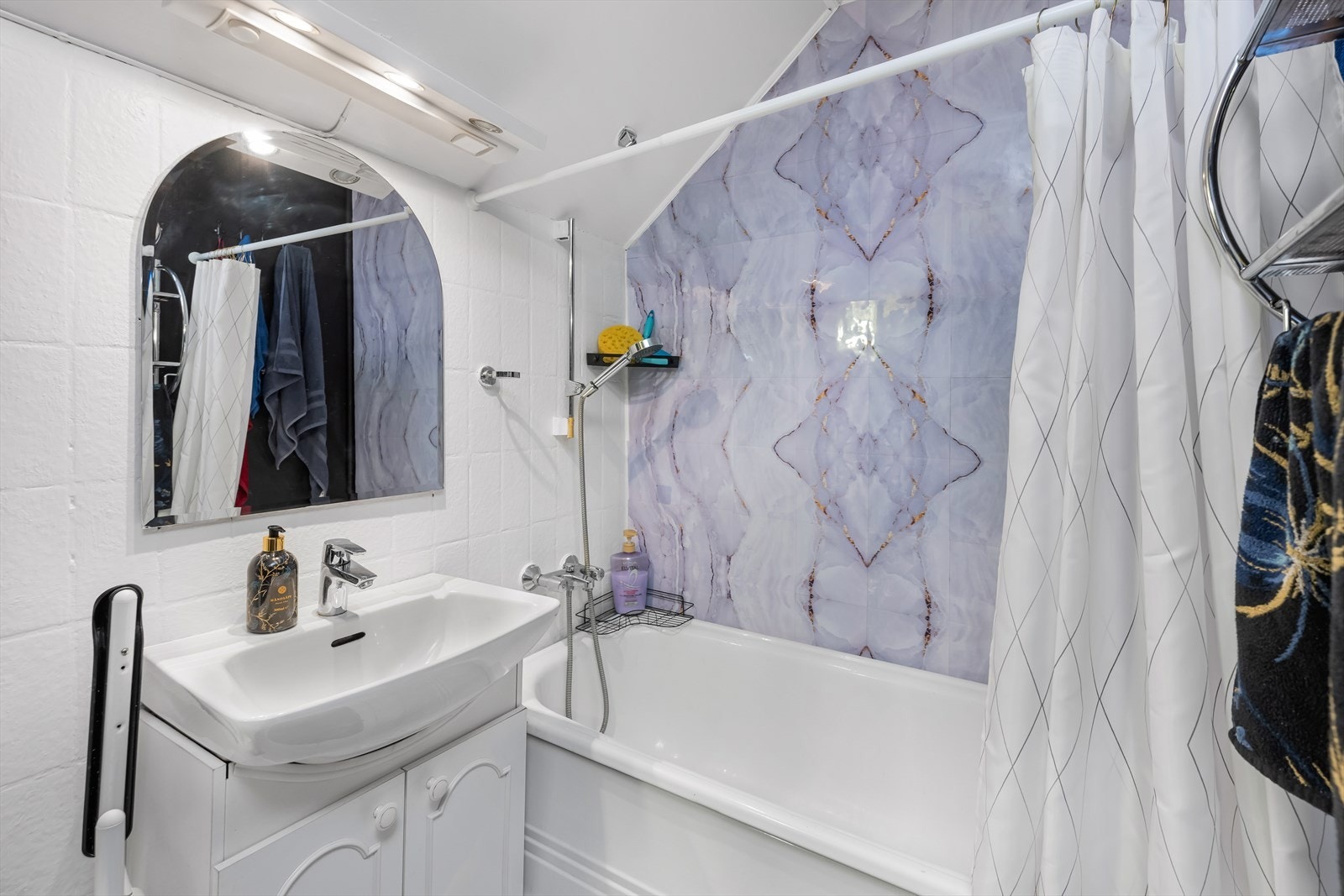 Baderomsinnredningen er lys og profilert i 60 cm. bredde. Et ekstra veggskap er montert for å øke lagringsplassen. Galleribilde