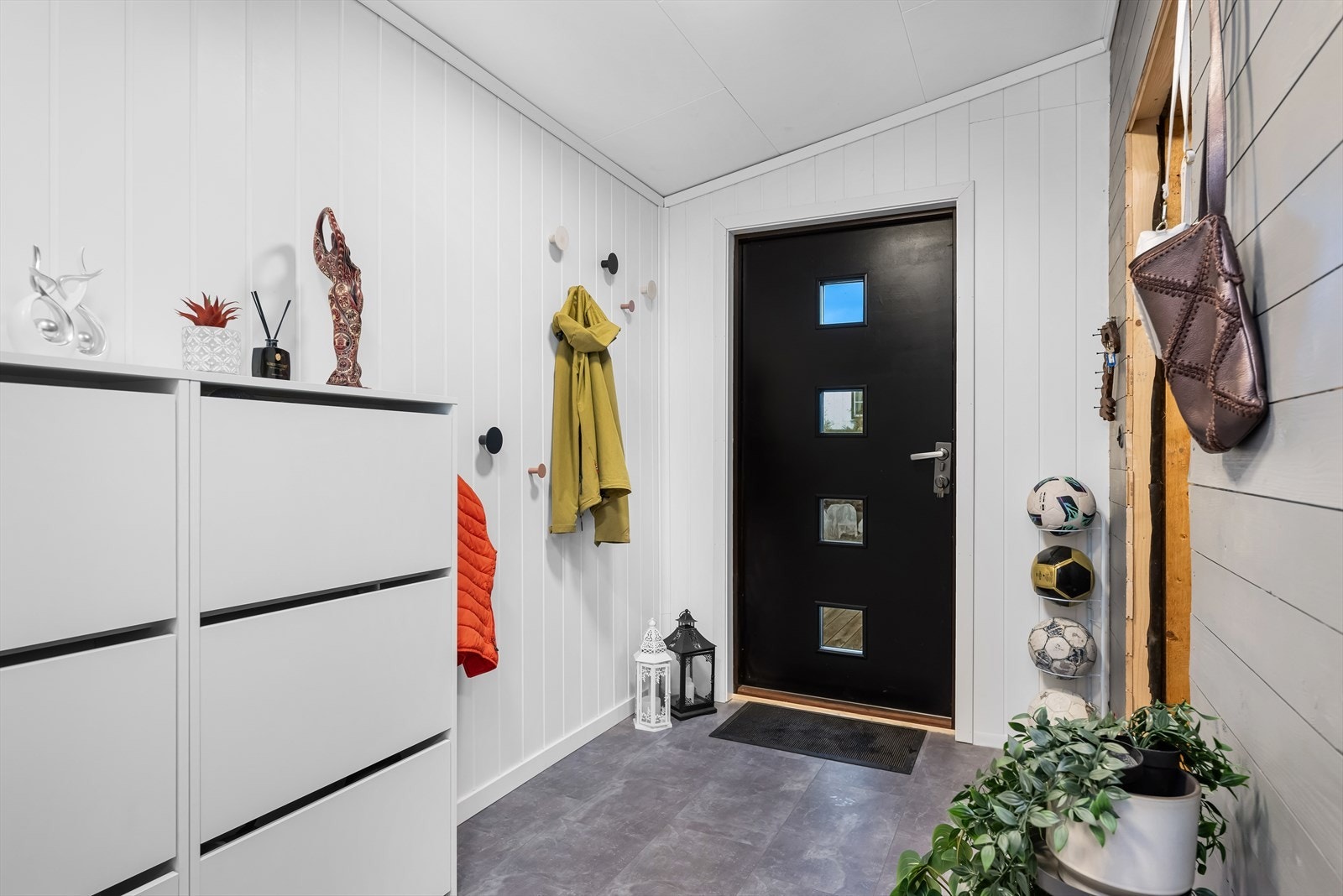 Fra det overbyggede inngangspartiet kommer en inn i en stor og luftig gang med moderne overflater og fargevalg. Galleribilde