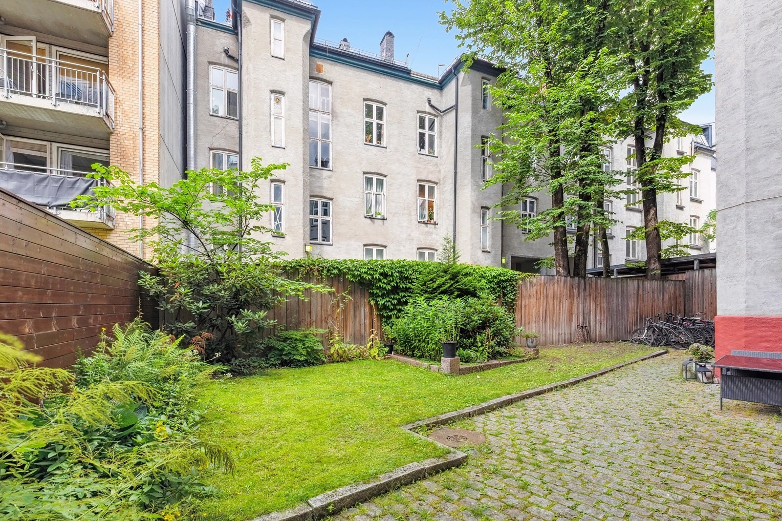 Pent opparbeidet felles bakgård med sittegrupper, gressplen og hyggelig beplantning Galleribilde