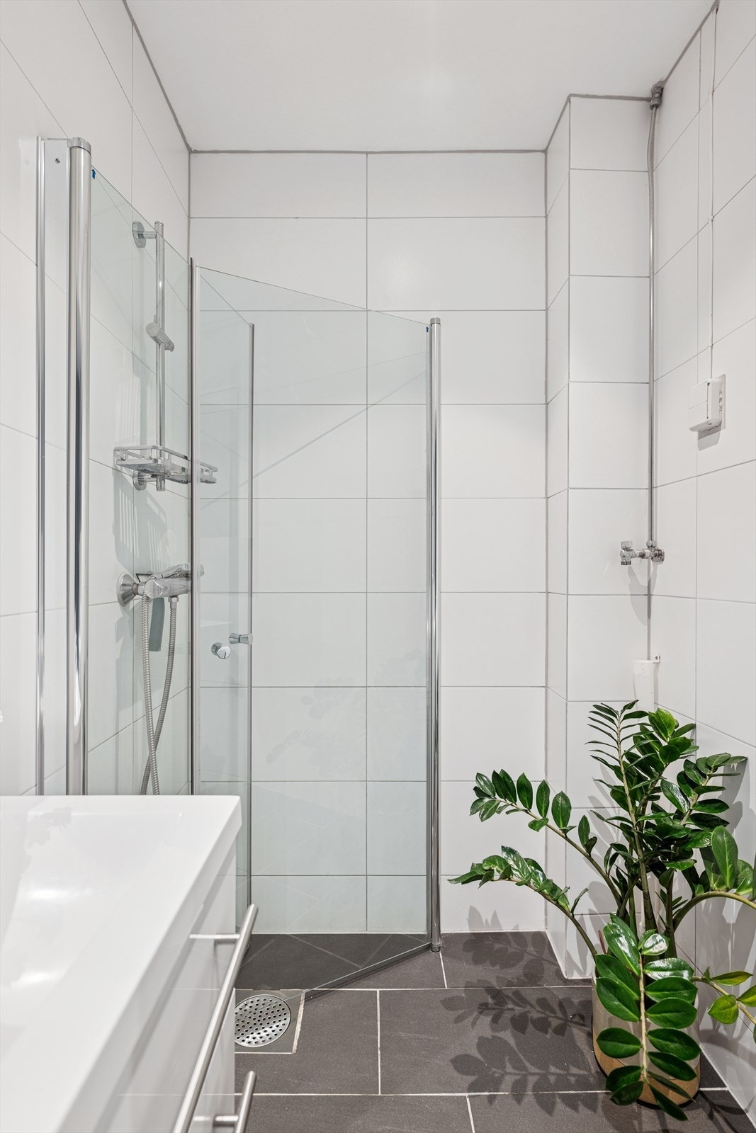 Pent fliselagt bad med moderne innreding. Her er det varmekabler på gulv og opplegg til vaskemaskin Galleribilde