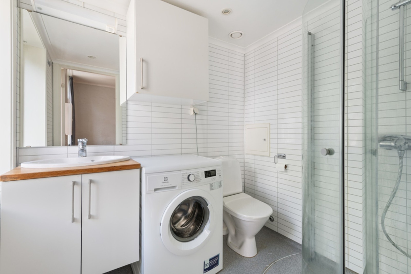 Pent bad med dusj, wc, servant med skap og opplegg til vaskemaskin. Galleribilde