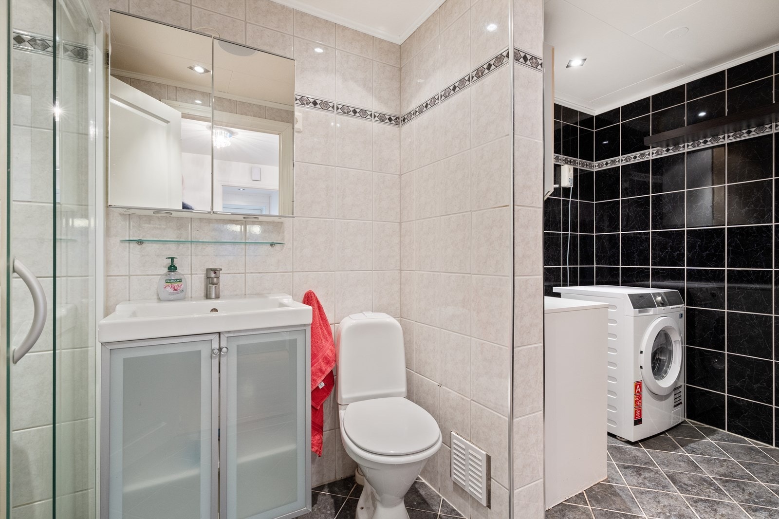 Lyst flislagt bad med servant og toalett. Galleribilde