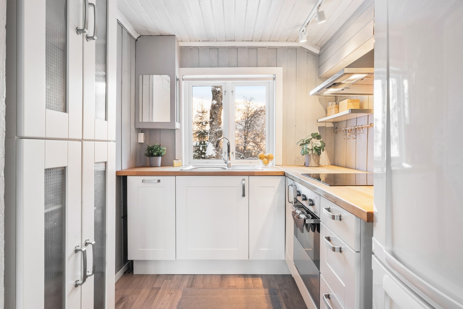 Fint kjøkken med profilerte fronter og heltre benkeplate med nedfelt vask av stål. Galleribilde