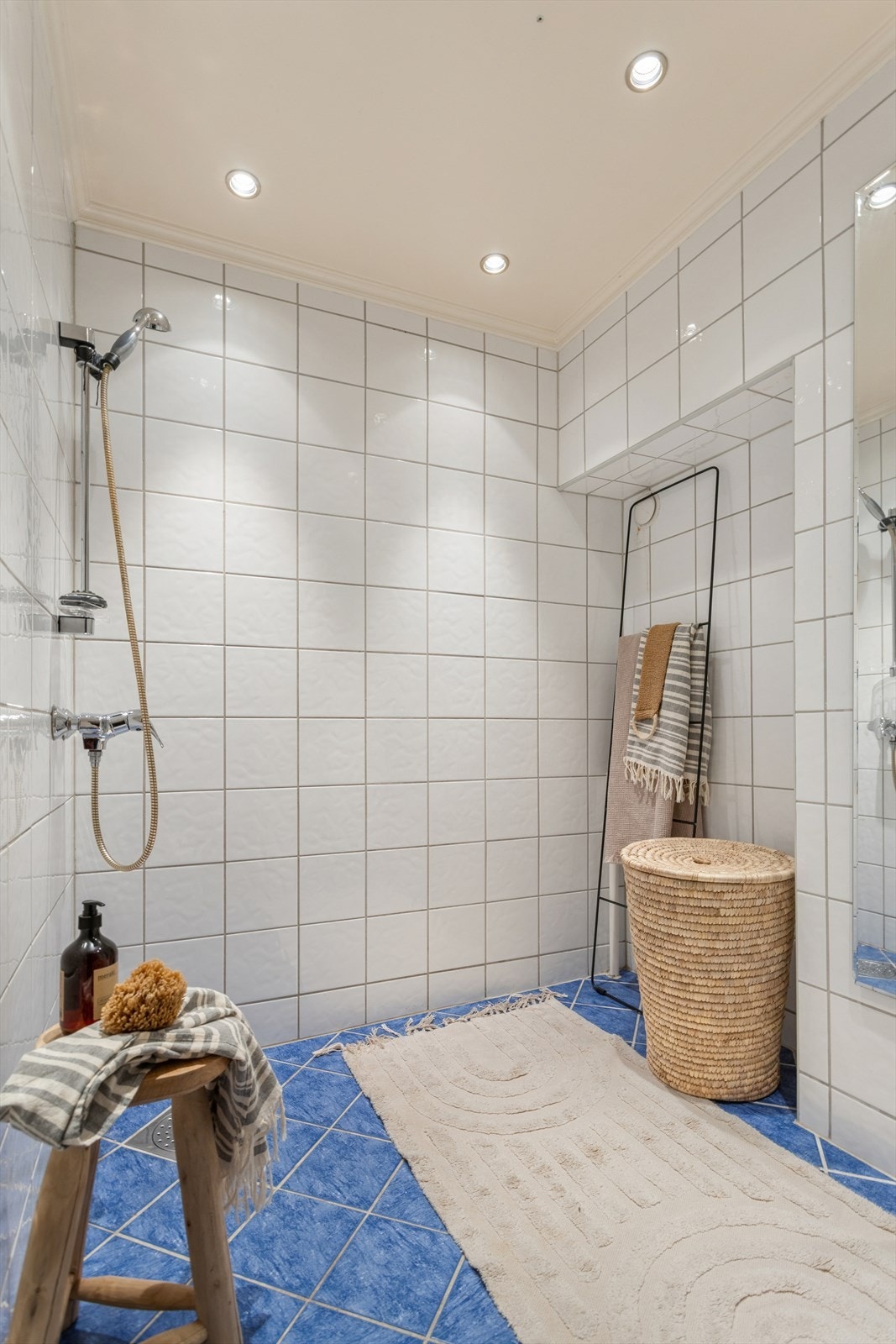 Baderom 2 er i dag innredet med dusj og opplegg til vaskemaskin. Dette badet er i følge tidligere salgsoppgave fra 2002 og har i likhet med det andre badet downlights i tak og gulvvarme. Galleribilde