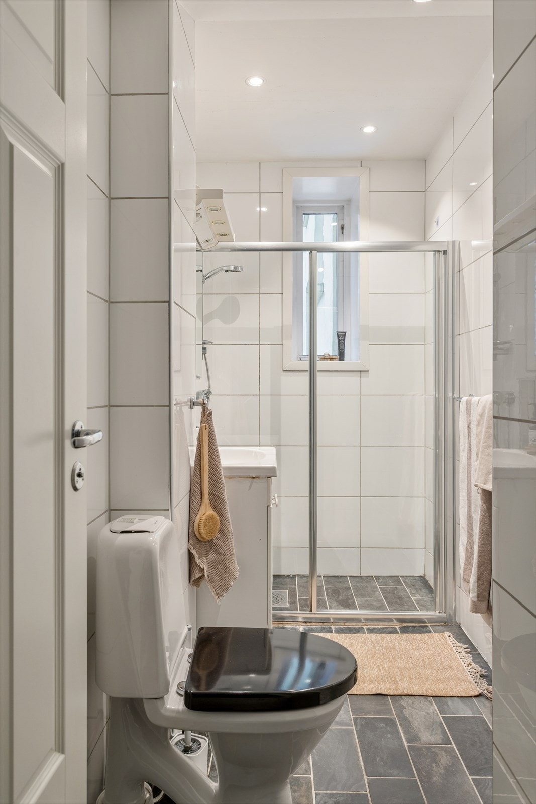 Baderomsinnredningen er bestående av servant med underskap, speilskap med overlys, gulvmontert klosett og dusjhjørne med skyvedør. Galleribilde