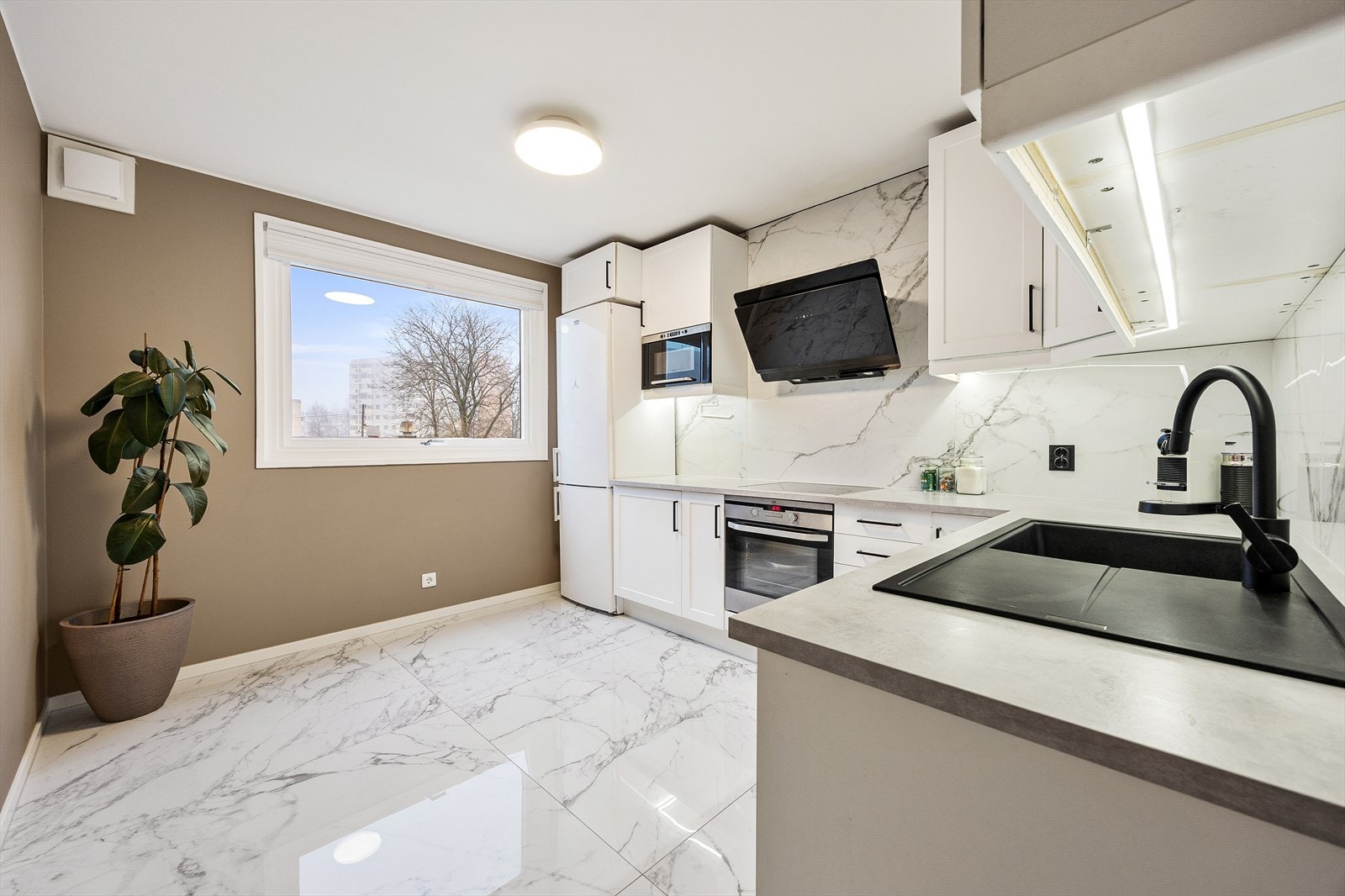 Innredningen er utstyrt med en sort, underlimt oppvaskkum med blandebatteri fra Grohe, integrert stekeovn, mikrobølgeovn og nedfelt platetopp. Galleribilde