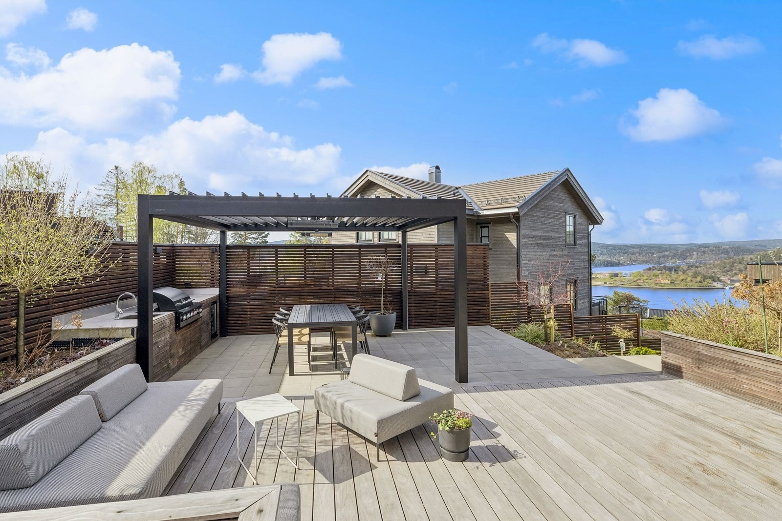 Fra kjøkken er det utgang til platting lagt med steinheller og terrassebord. Her det det god plass til det man måtte trenge av utemøbler, putekasse, grill og lignende. Galleribilde