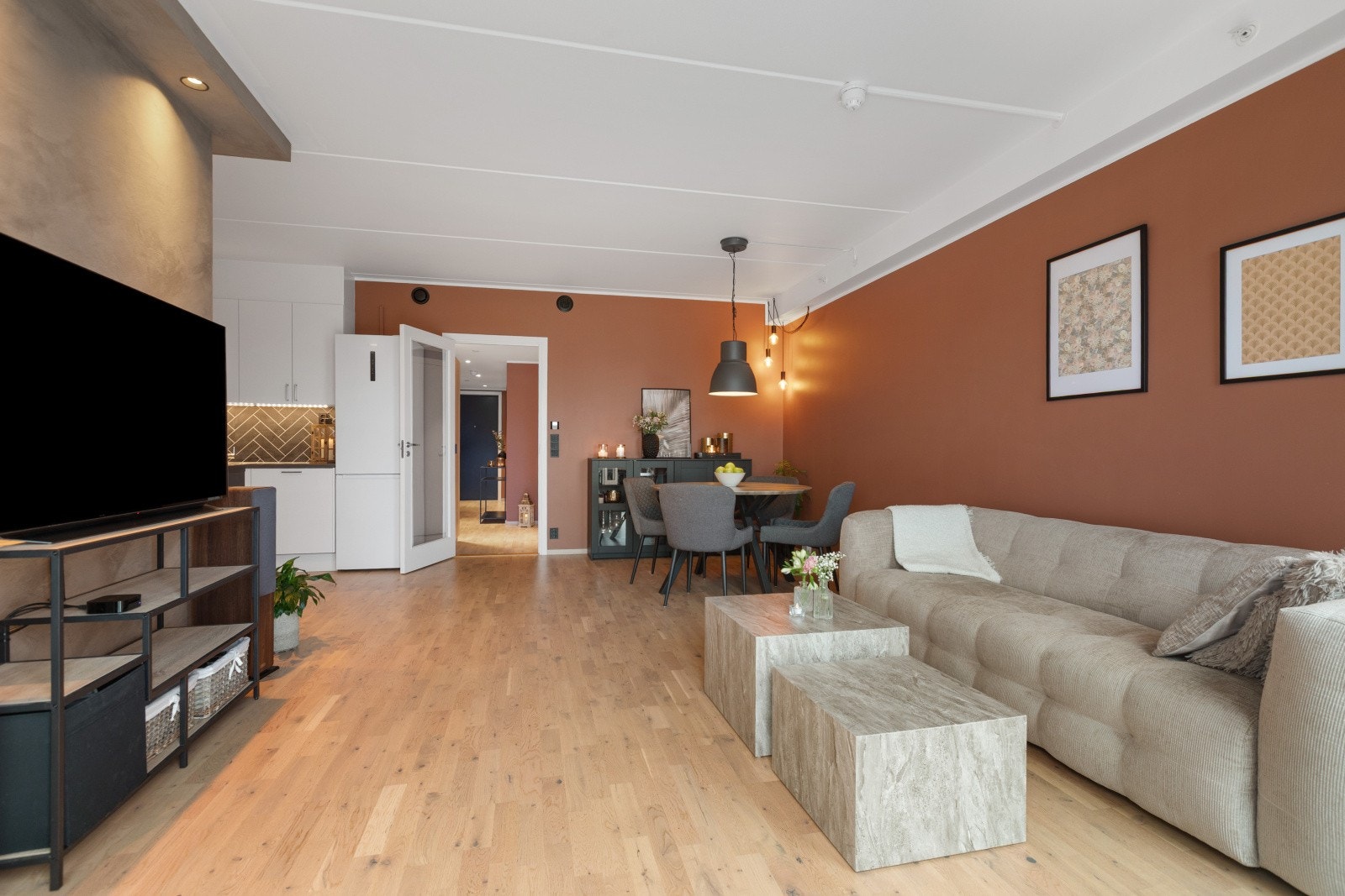 Lenger inn i leiligheten møter vi en romslig og åpen kjøkken- og stueløsning, som skaper en lys og innbydende atmosfære perfekt for både hverdagsliv og sosiale sammenkomster. Galleribilde