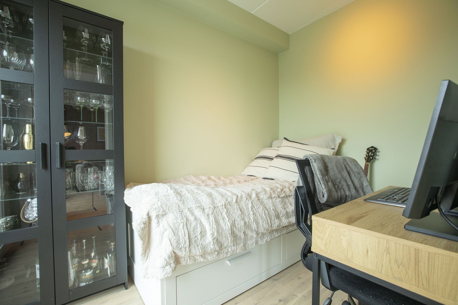 Rommet er malt i en tidløs og delikat grønnfarge, som tilfører en beroligende og naturlig atmosfære til innredningen. Galleribilde