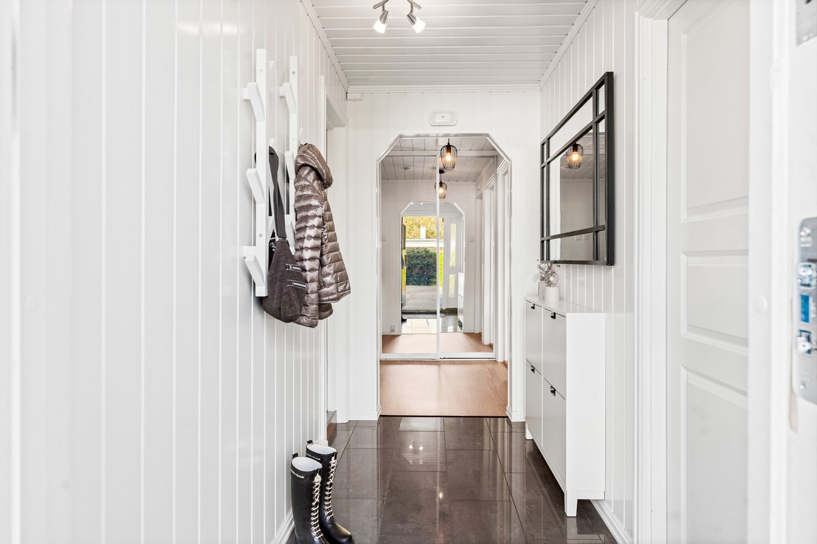I entréen er det plass til å henge fra seg yttertøy og sette fra seg sko. Det er montert praktisk skyvedørsgarderobe med speilfronter, samt tilgang til kott. Galleribilde