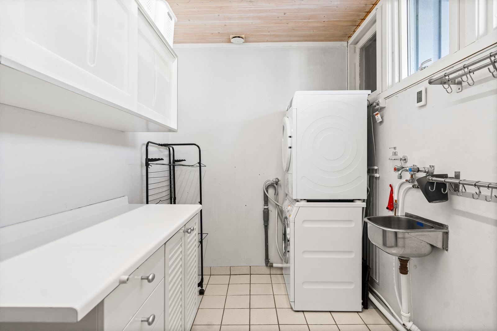 Boligen har et praktisk vaskerom, med flislagte gulv og tapetserte vegger. Rommet har utslagsvask i rustfritt stål og benkeskap med glatte fronter. I tillegg er det opplegg for vaskemaskin. Galleribilde