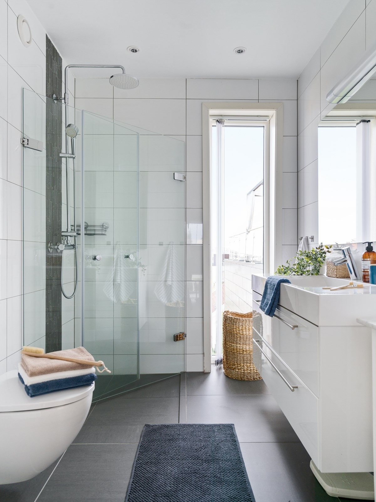 Flislagt bad med dusj, vegghengt toalett og moderne innredning. Galleribilde