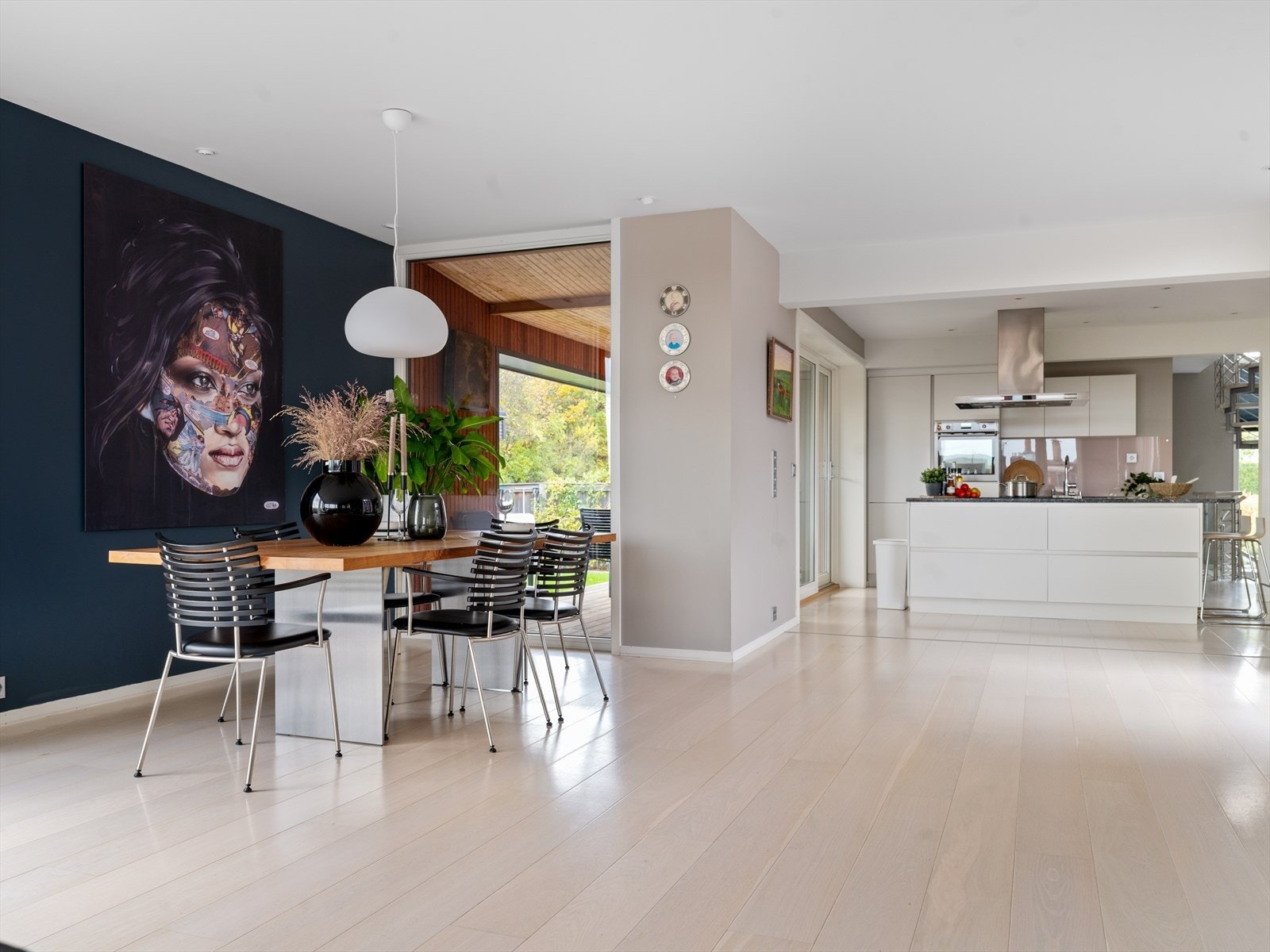 Spisestue med lysinnslipp fra to sider og utsikt mot hage - elegant og innbydende. Galleribilde