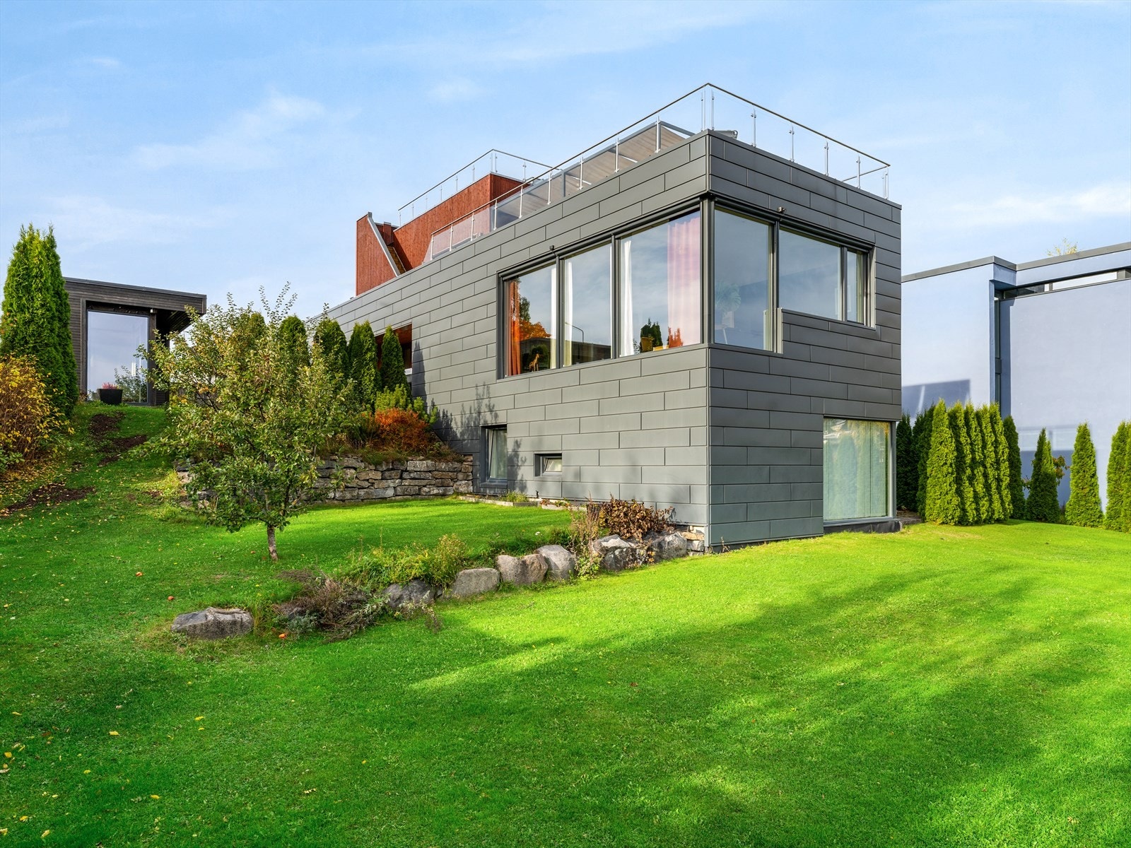 Plenlagt hage med vintergrønn hekk og prydvekster - privat og harmonisk. Galleribilde