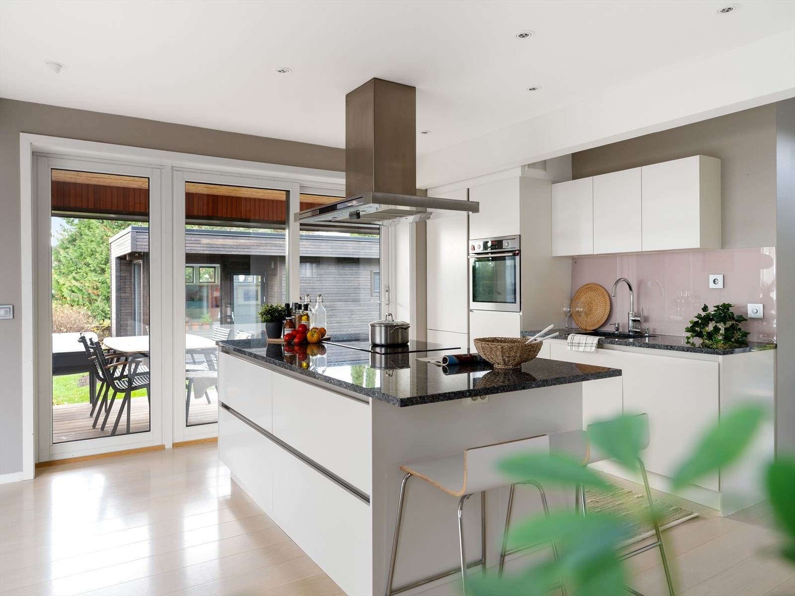 HTH kjøkkeninnredning i åpen løsning med vinduer fra gulv til tak og direkte utgang til to terrasser. Galleribilde