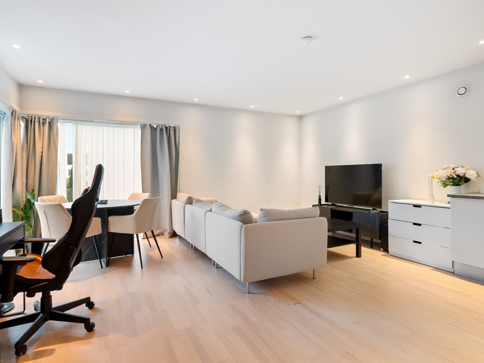 Lys stue med moderne overflater og vinduer mot hage - separat og diskret fra hoveddel. Galleribilde