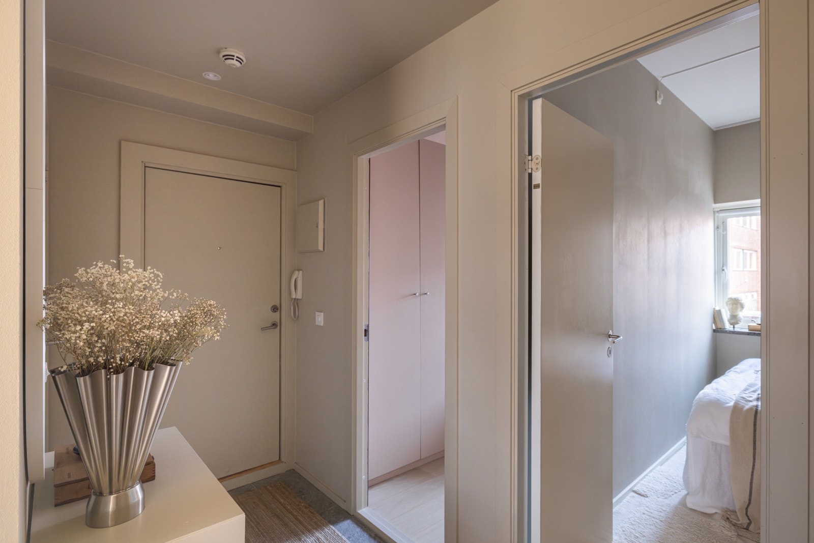 Entréen har mørke fliser på gulv, glatte malte overflater og downlights i himlingen. Galleribilde