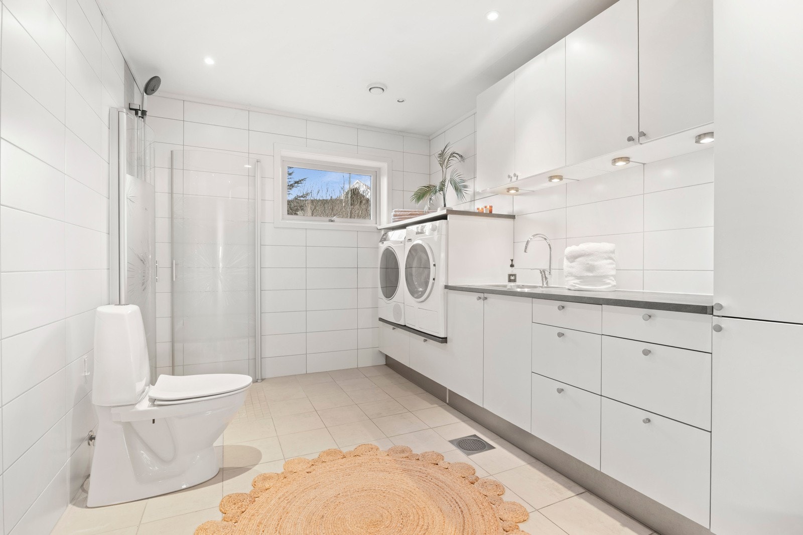 Kombinert bad/vaskerom med adkomst fra det ene soverommet og fra gangen Galleribilde