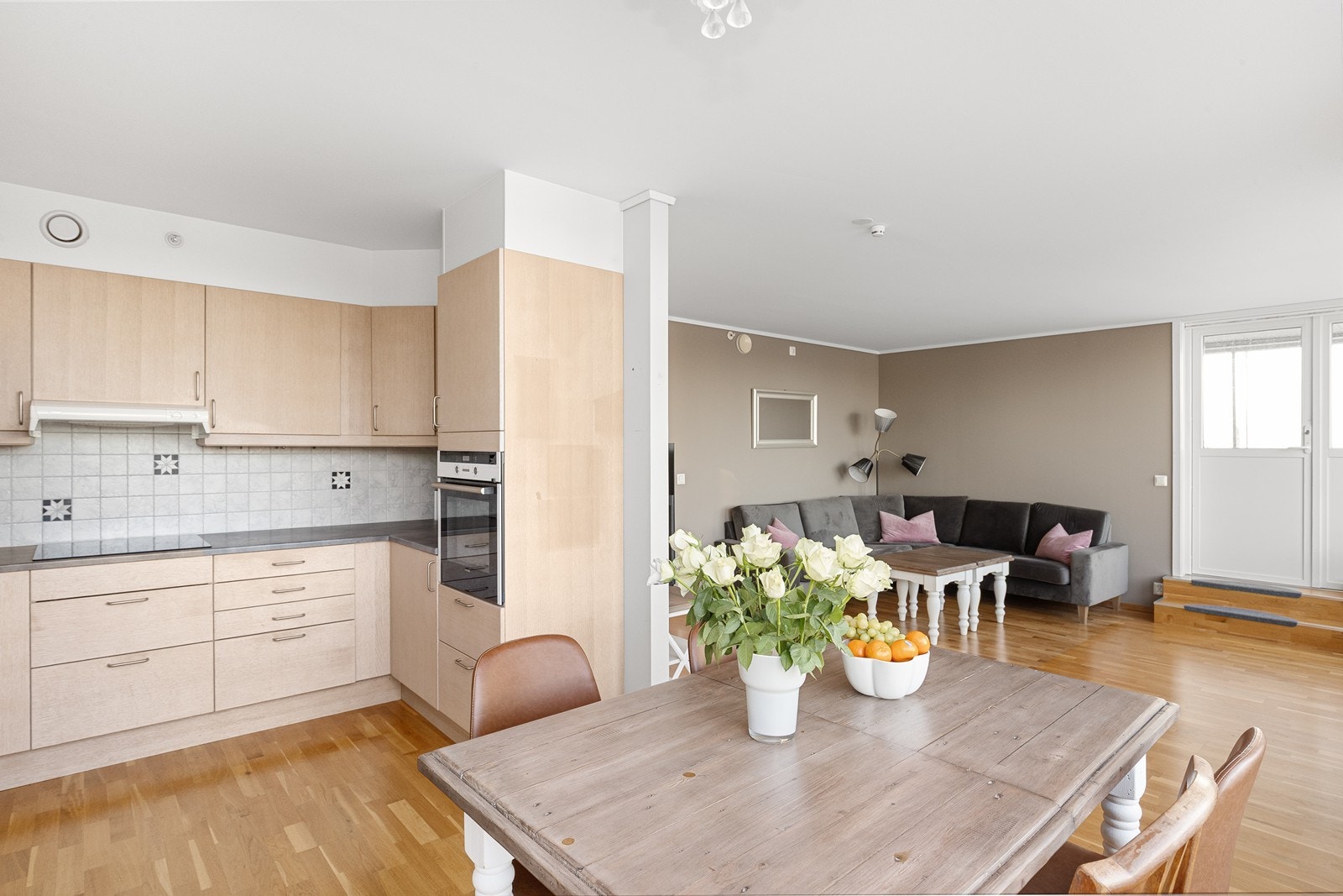 Den åpne løsningen mellom stue og kjøkken gir en luftig og sosial atmosfære Galleribilde