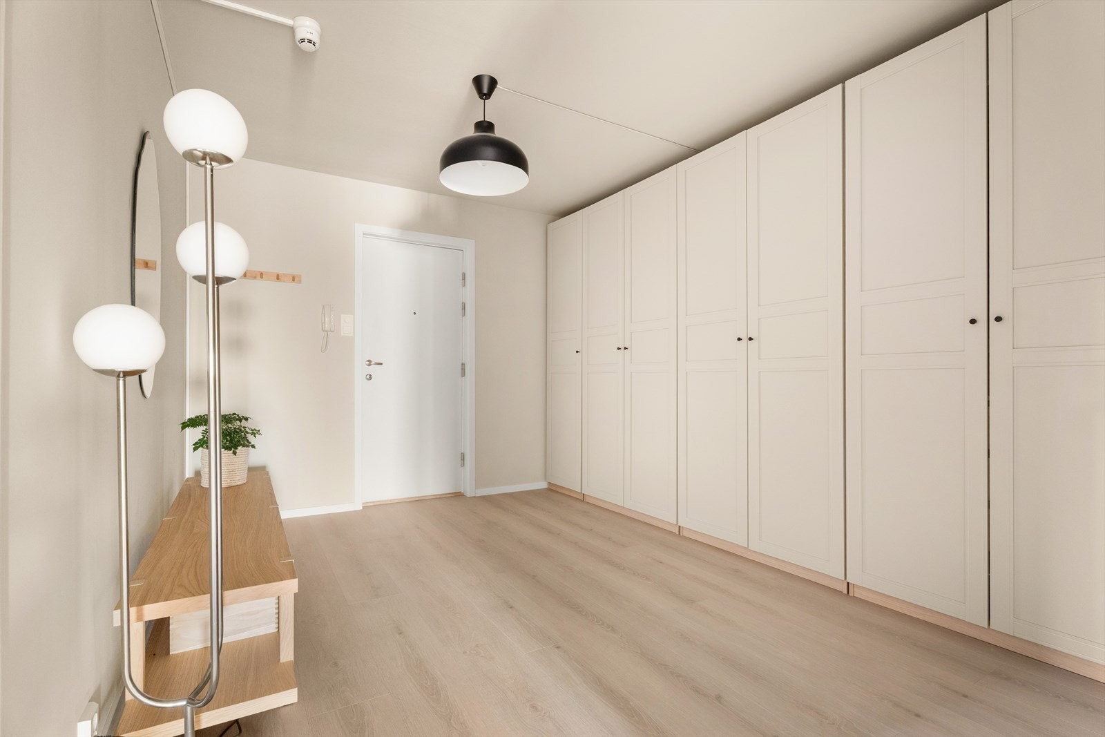 Innenfor døren ønskes du velkommen inn i en lys og svært romslig gang med lun laminat på gulvet og malte vegger i en moderne, gjennomført fargetone. Galleribilde