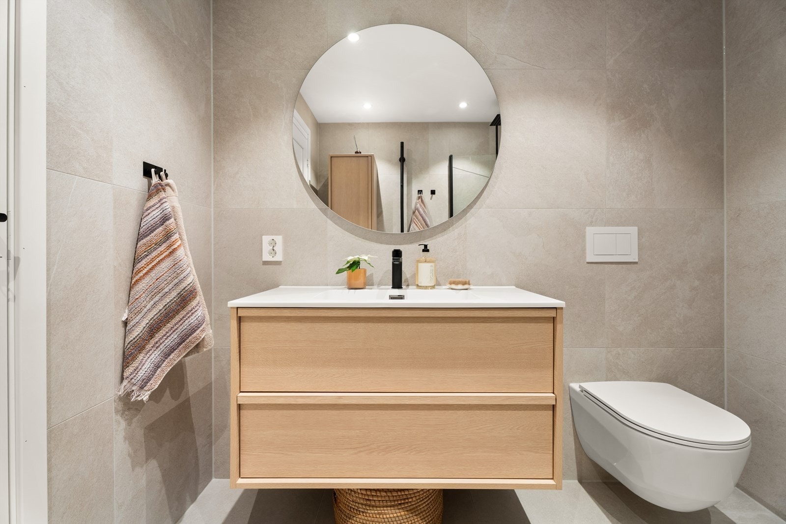 Baderommet er utført med elegante fliser på vegger og gulv, og det er installert elektriske varmekabler i gulvet som bidrar til god komfort. Galleribilde