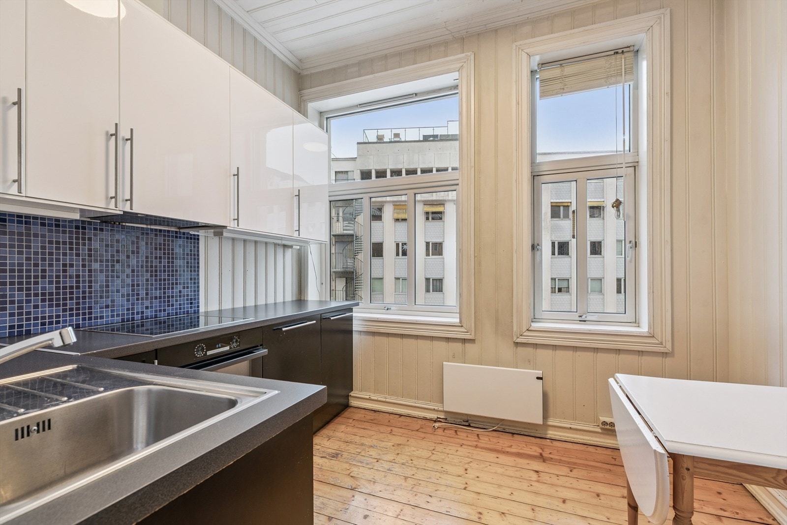 Kjøkken med spiseplass og integrerte hvitevarer. Vender mot bakgård. Galleribilde