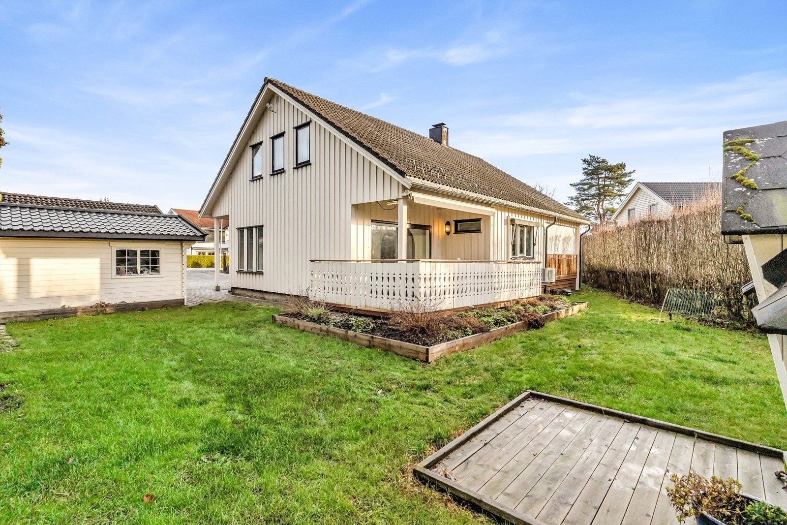 Eiendommen har en opparbeidet tomt med stor gressplen både på fremsiden og baksiden av huset Galleribilde