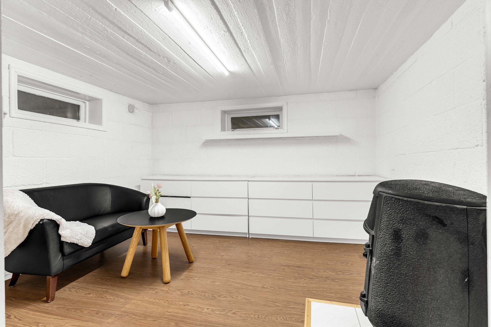 Fra gangen er det inngang til en bod, som er blitt benyttet som tv-stue. Rommet er ikke godkjent for varig opphold. Rommet er blitt innredet med sofa og bord, samt kommoder. Det står en vedovn i rommet. Galleribilde