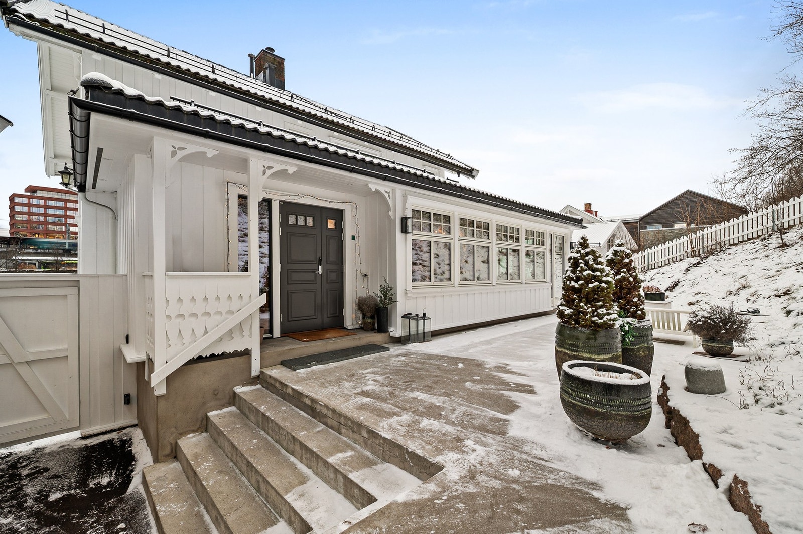 Pent og innbydende inngangsparti i klassisk sveitserstil, med dekorative detaljer og overbygget adkomst som gir god beskyttelse mot vær og vind. (varmekabler i trapp) Galleribilde