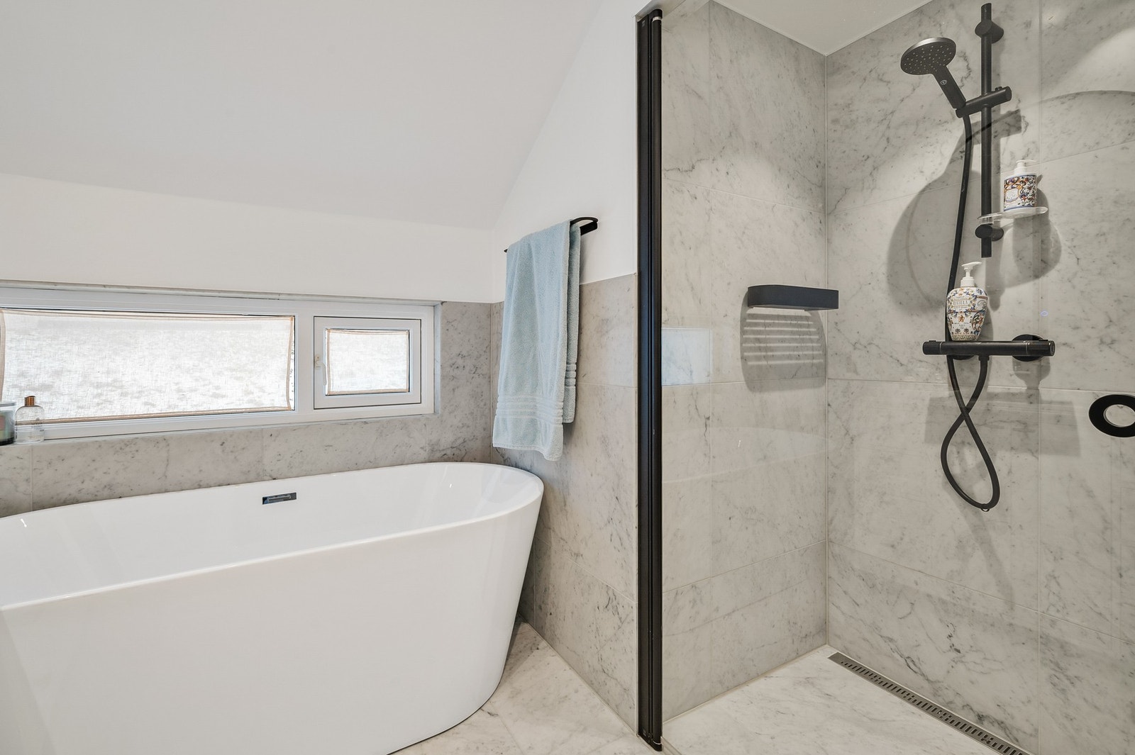 Delikat og tidsriktig baderom fra 2022 med gjennomførte materialvalg. Romslig dusjnisje. Galleribilde