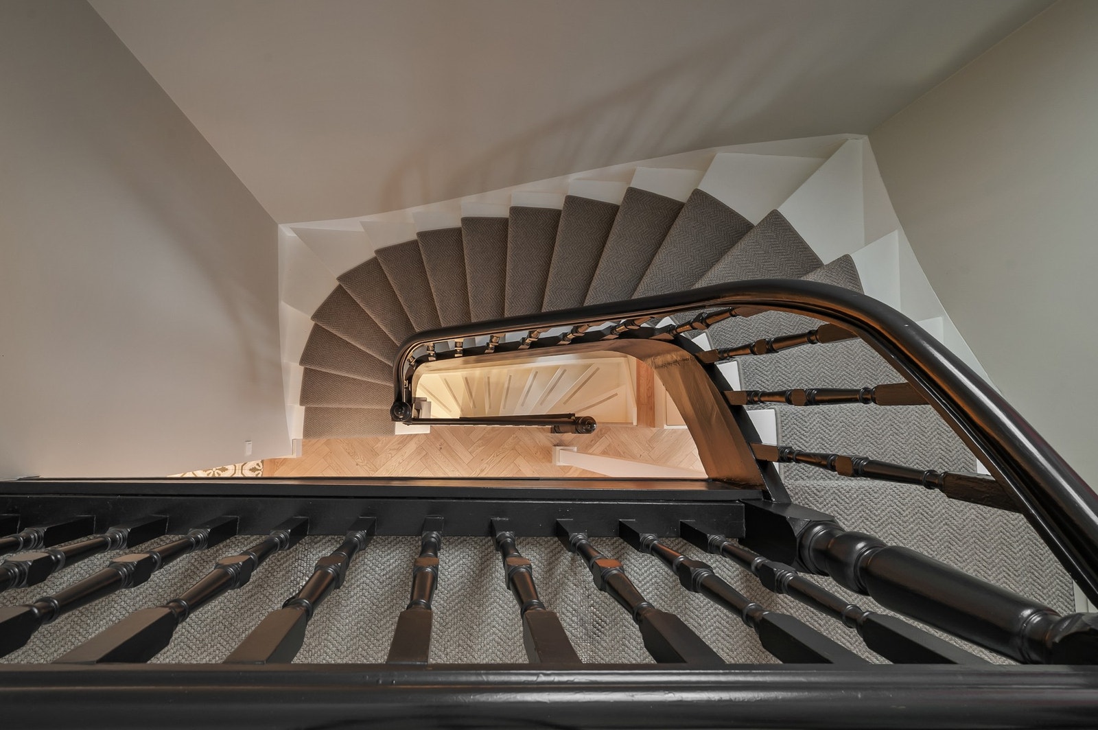 Trappen slynger seg elegant gjennom etasjene og fungerer som et arkitektonisk smykke. Galleribilde