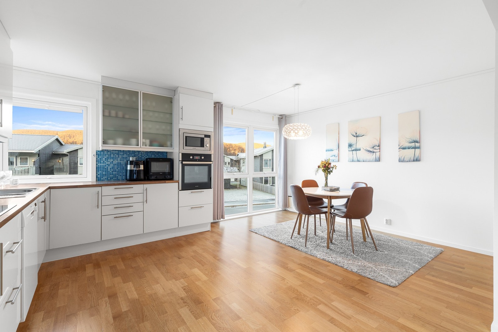 Vegg over benk er flissatt med blå fliser og det er avtrekk via sentralt avtrekksanlegg i boligen Galleribilde