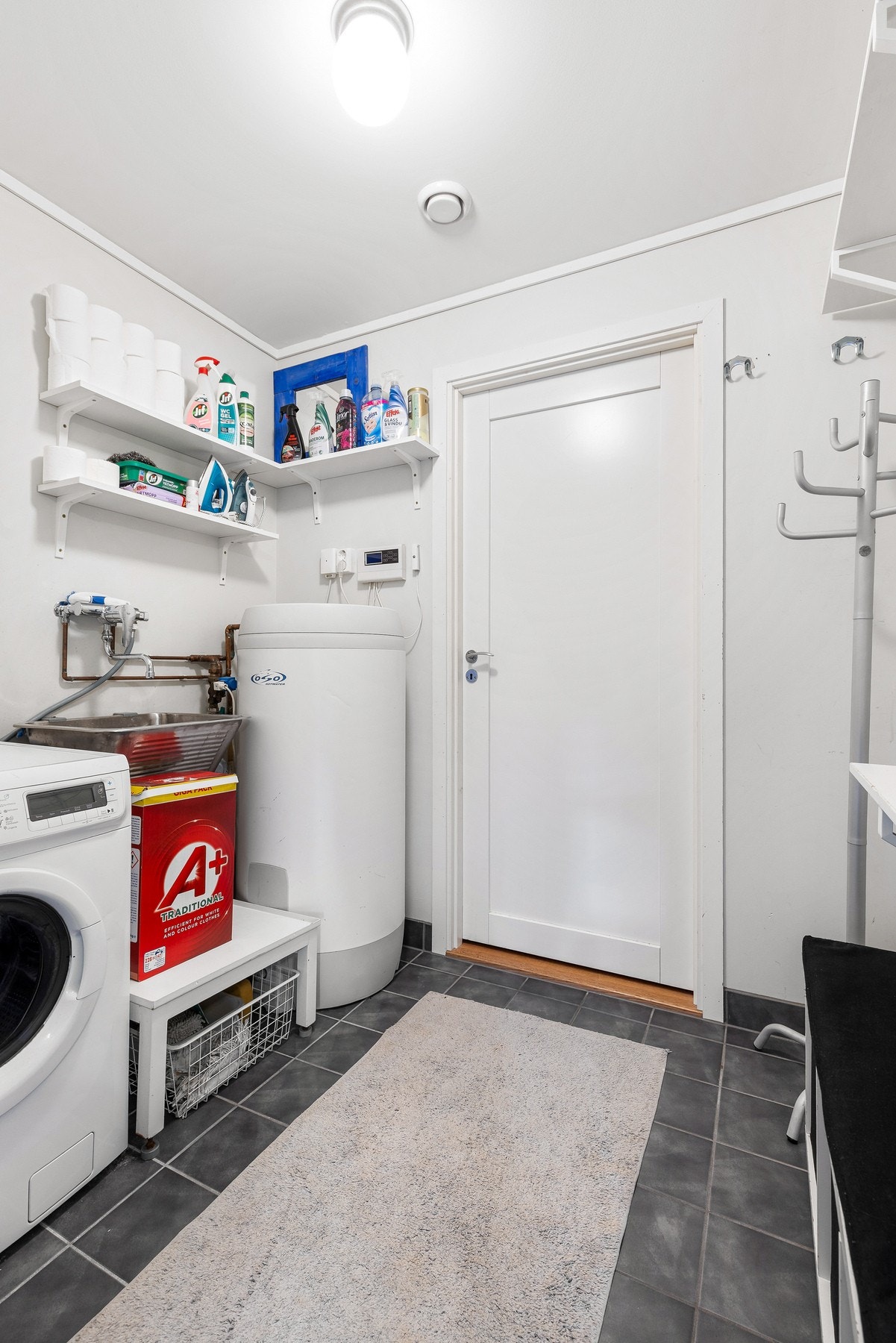 Separat vaskerom med elektriske varmekabler, skyllekar og opplegg for vaskemaskin Galleribilde