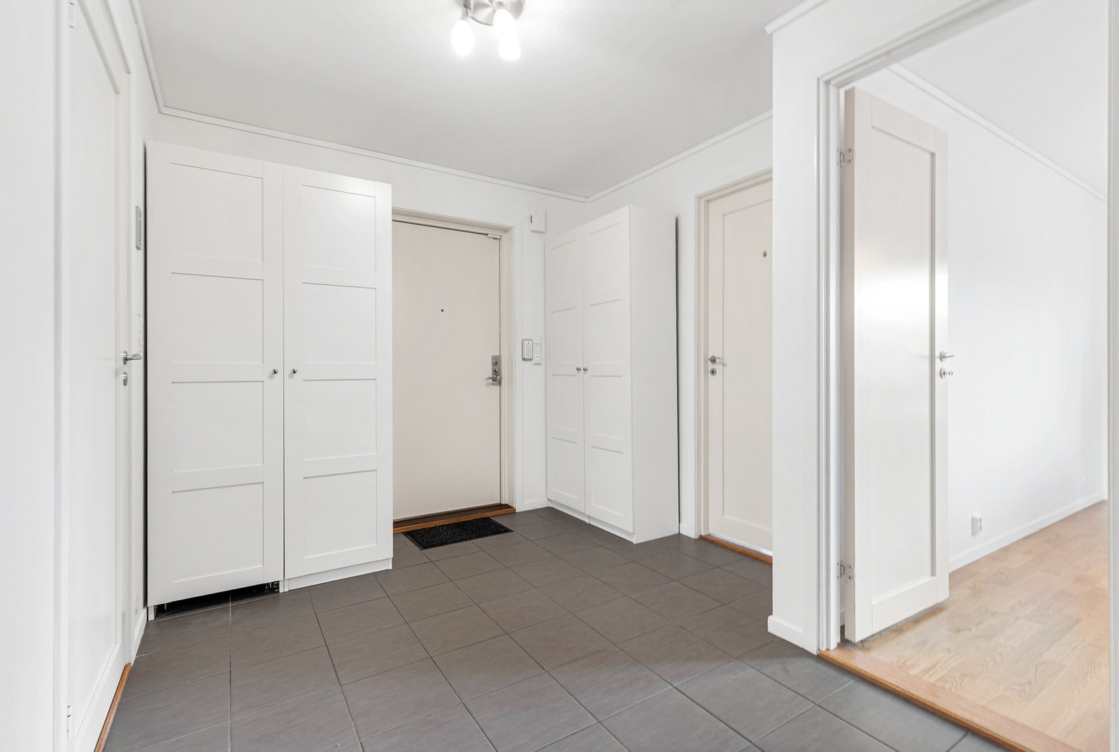 Romslig hall/entré med flislagt gulv og god plass til garderobeskap Galleribilde