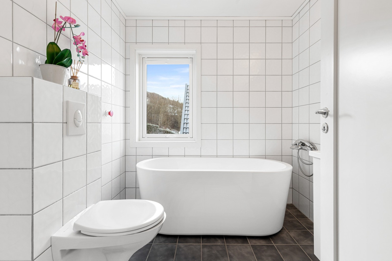 Pent bad med fliser på gulv- og veggflater samt elektriske varmekabler Galleribilde