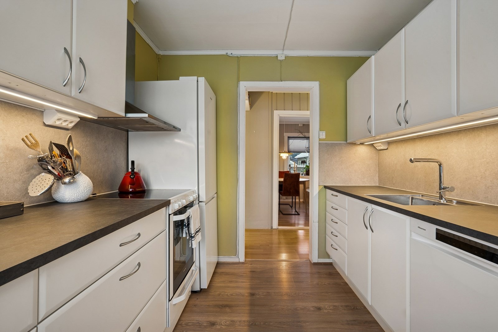 Kjøkkenet har plass til frittstående hvitevarer bestående av komfyr, oppvaskmaskin og kjøl-/fryseskap. Galleribilde