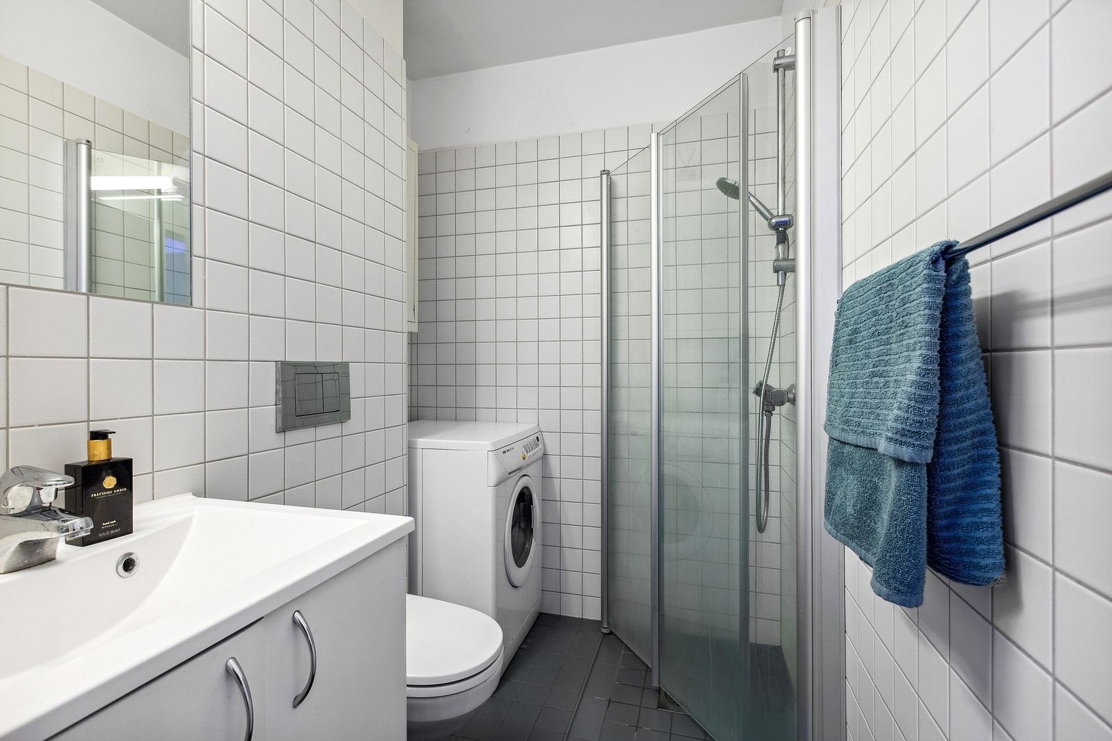 Flislagt bad med vaskemaskin. Galleribilde