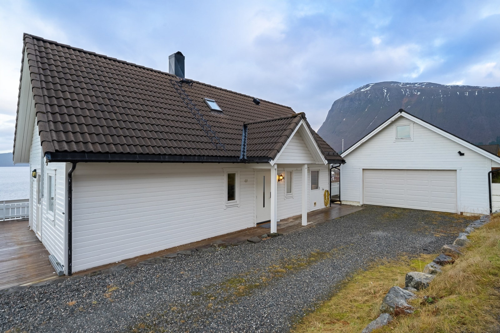 Innkjørsel og garasje som muligheter for parkering på eiendommen. Galleribilde