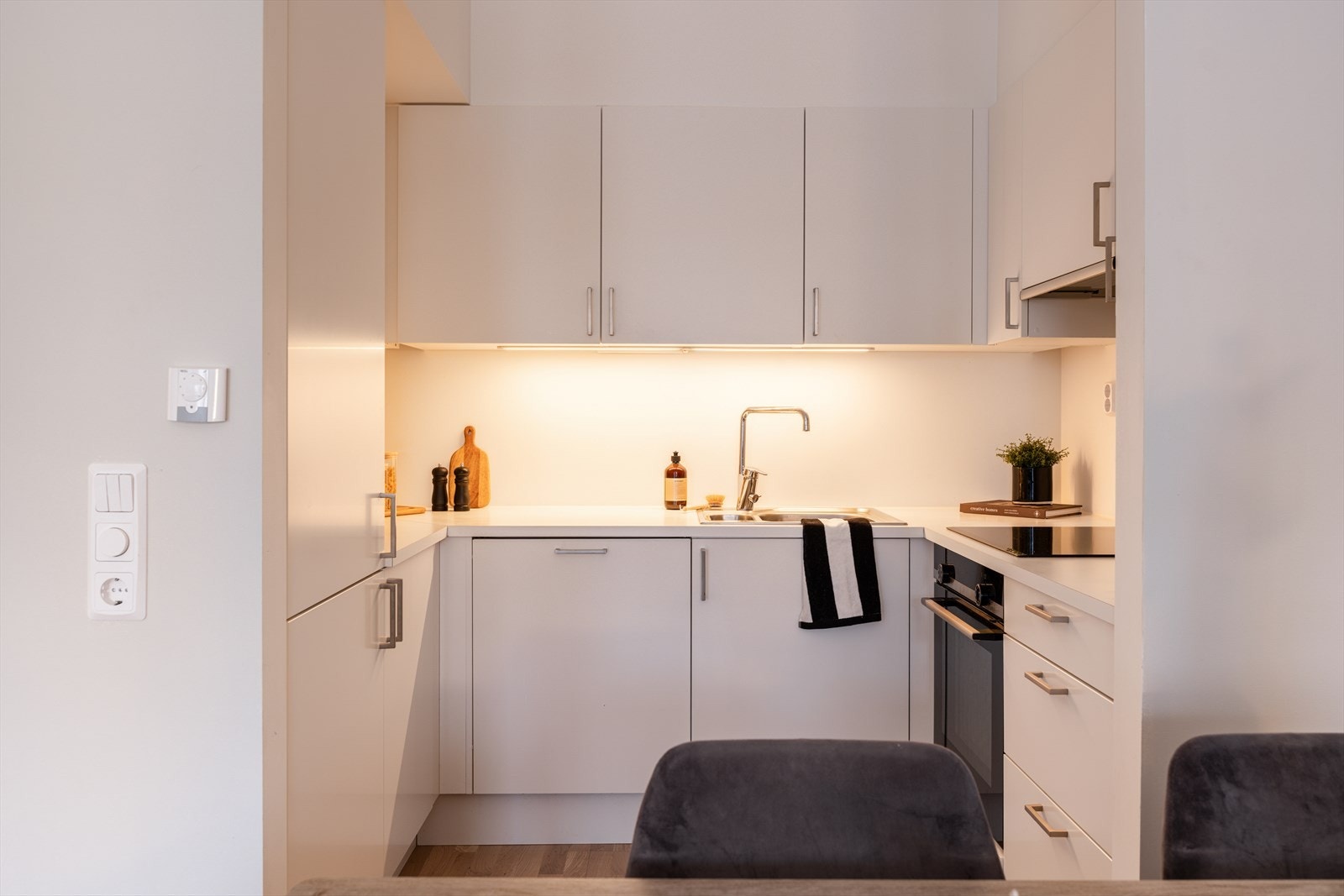 Kjøkkenet fra Sigdal har en stilren innredning med glatte, hvite fronter og laminat benkeplate. Galleribilde