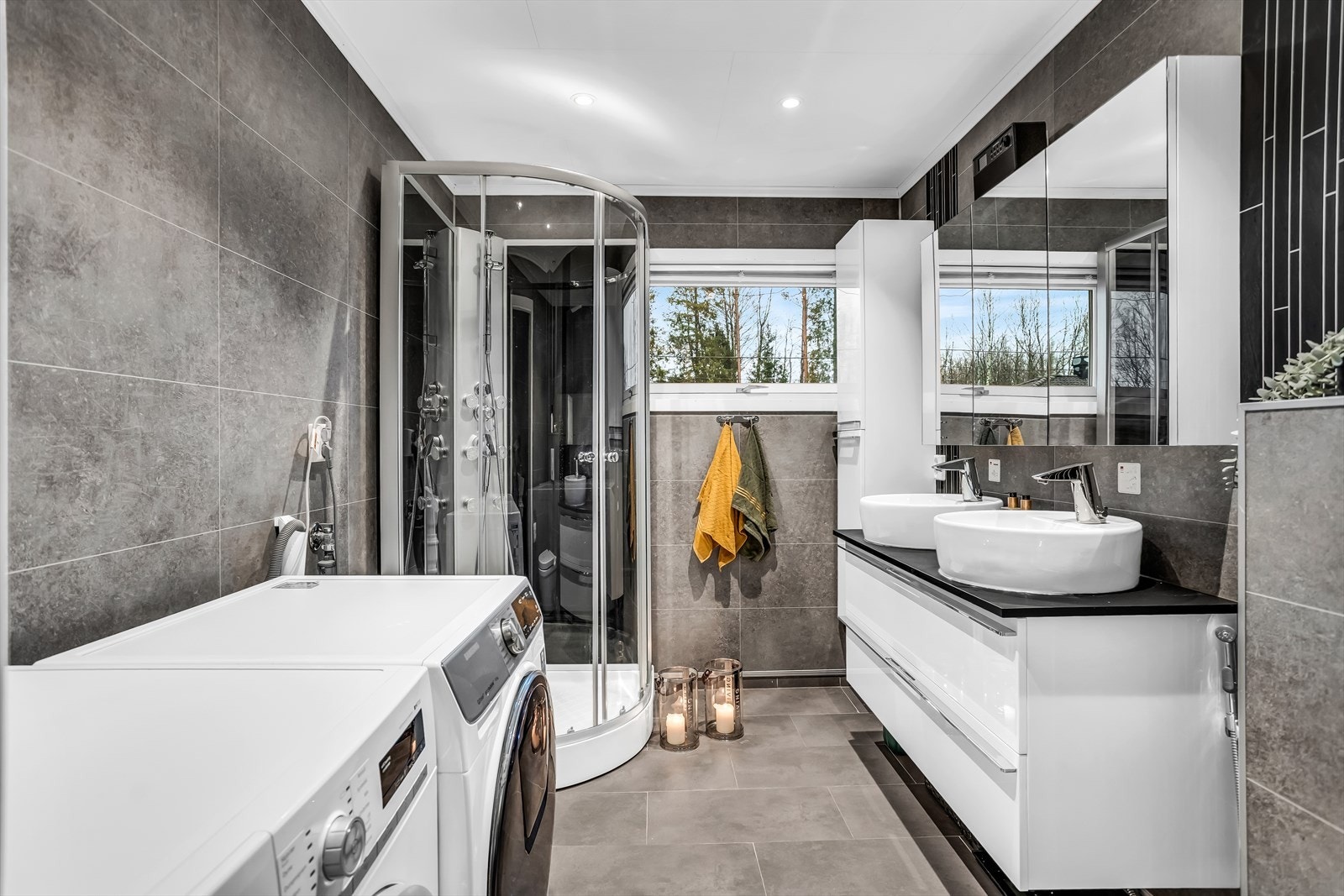 Hovedbadet er helfliset og har dobbel servant, dusjkabinett og opplegg for vaskemaskin. Galleribilde