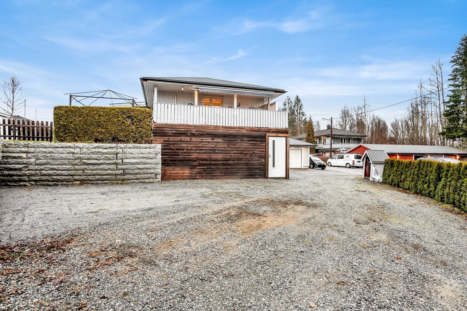 Gruset innkjørsel og biloppstillingsplass på nedsiden av boligen. Galleribilde