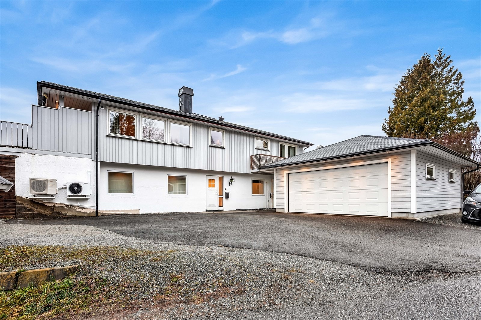 Asfaltert gårdsplass med rikelig biloppstillingsplass foran den doble garasjen. Galleribilde