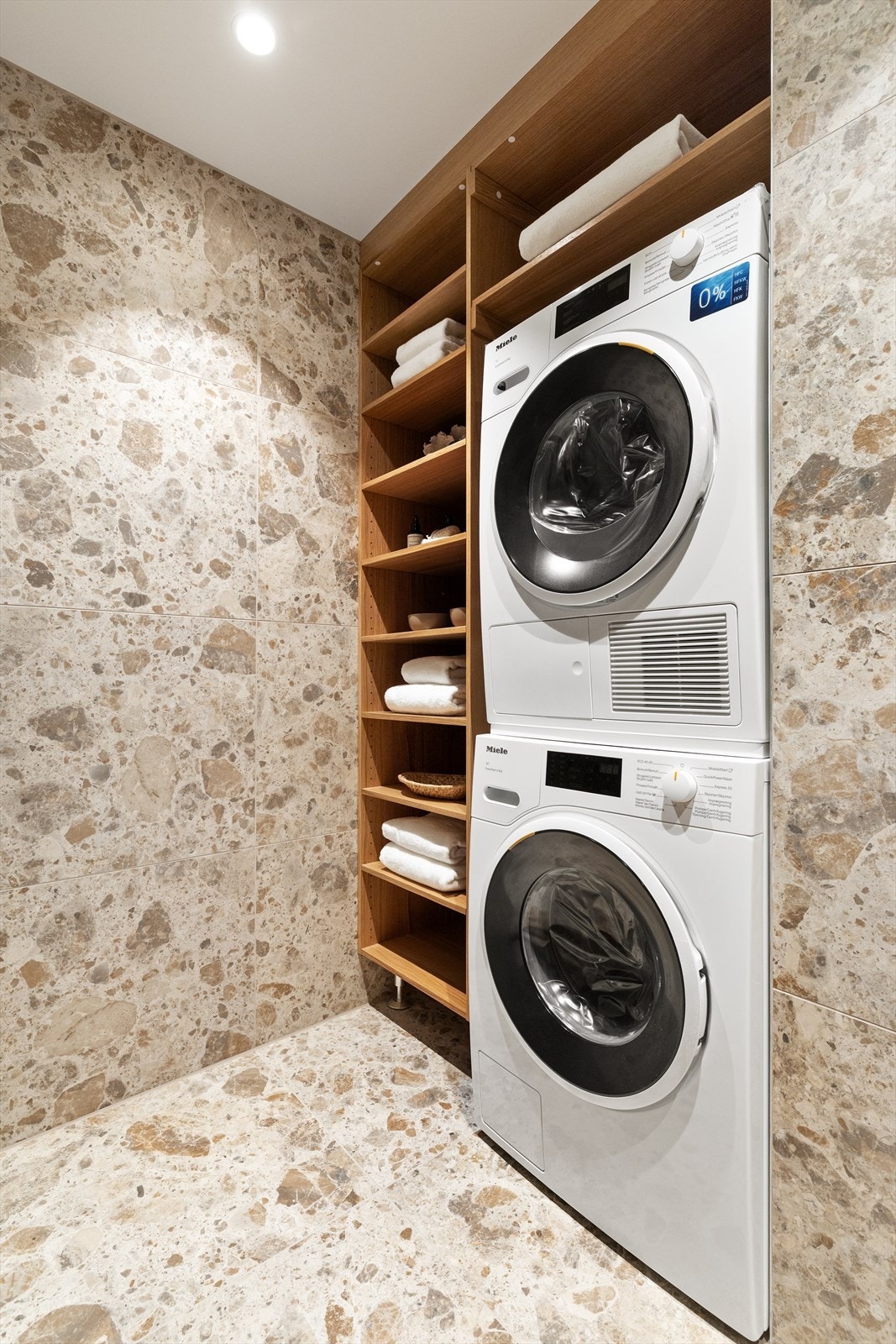 Plassbygget hyllesystem med vaskesøyle gir gode oppbevaringsmuligheter på badet. Denne er også utstyrt med vaskemaskin og tørketrommel fra Miele. Galleribilde