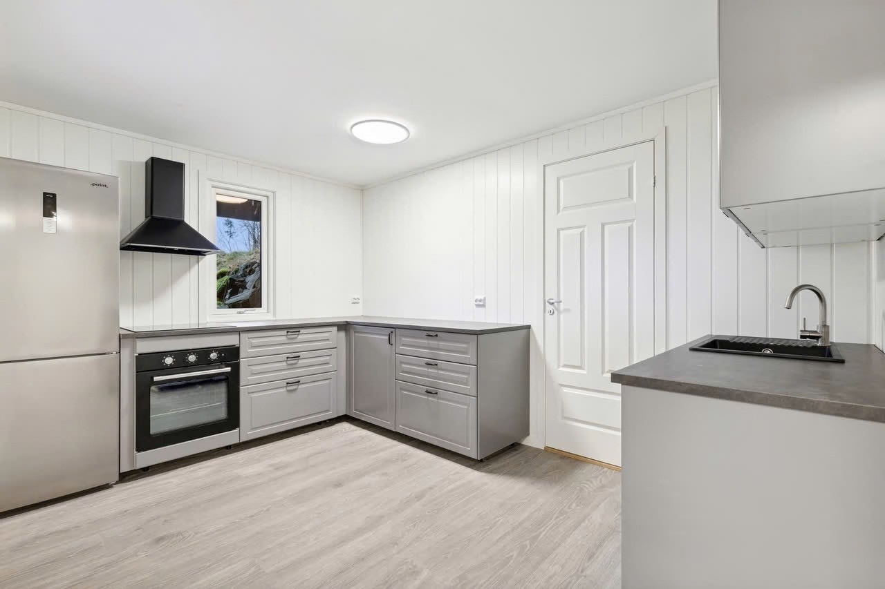 Stort kjøkken med mye skap- og benkeplass. Ny innredning og ubrukte hvitevarer. Galleribilde